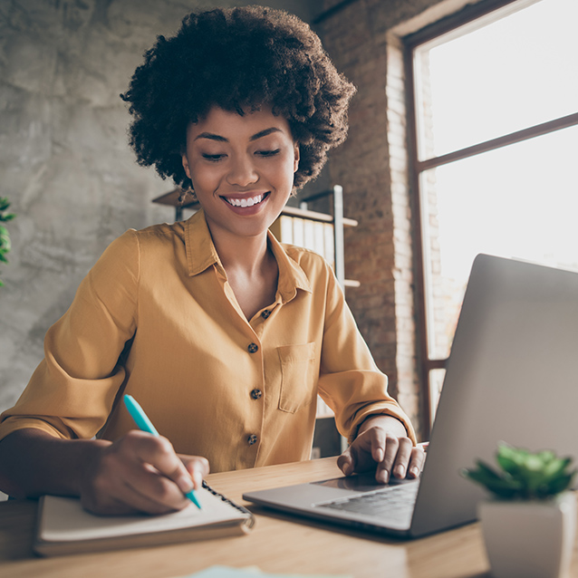 Woman smiling while writing in her notepad