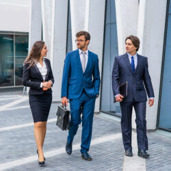 3 people walking while dressed in business attire