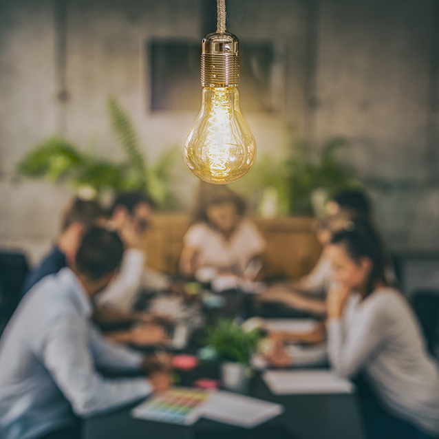 Lightbulb shining above people collaborating