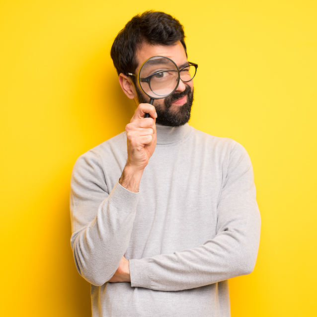 Man looking through magnifying glass