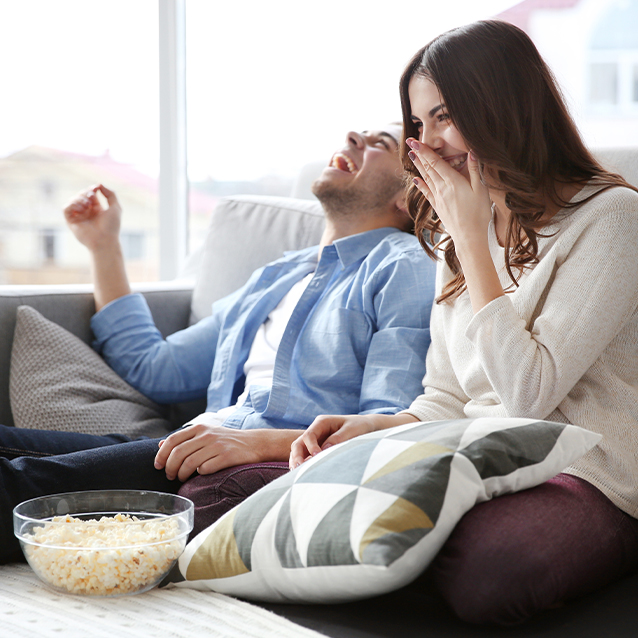 Couple laughing eating popcorn