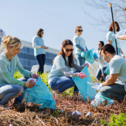 Volunteers from a business in a park area cleaning garbage